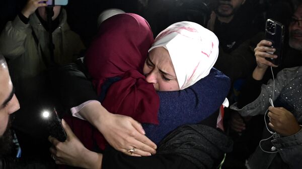 A newly released prisoner (L) greets a relative during a welcome ceremony following the release of Palestinian prisoners from Israeli jails in exchange for Israeli hostages held in Gaza by Hamas since the October 7 attacks, in Ramallah in the occupied West Bank early on November 30, 2023 - Sputnik Africa