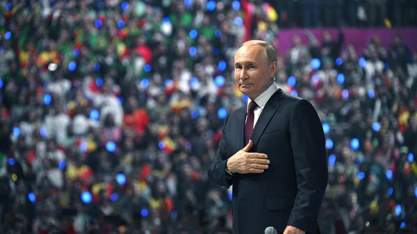 Russian President Vladimir Putin greets the audience the closing ceremony of the 2024 World Youth Festival - Sputnik Africa