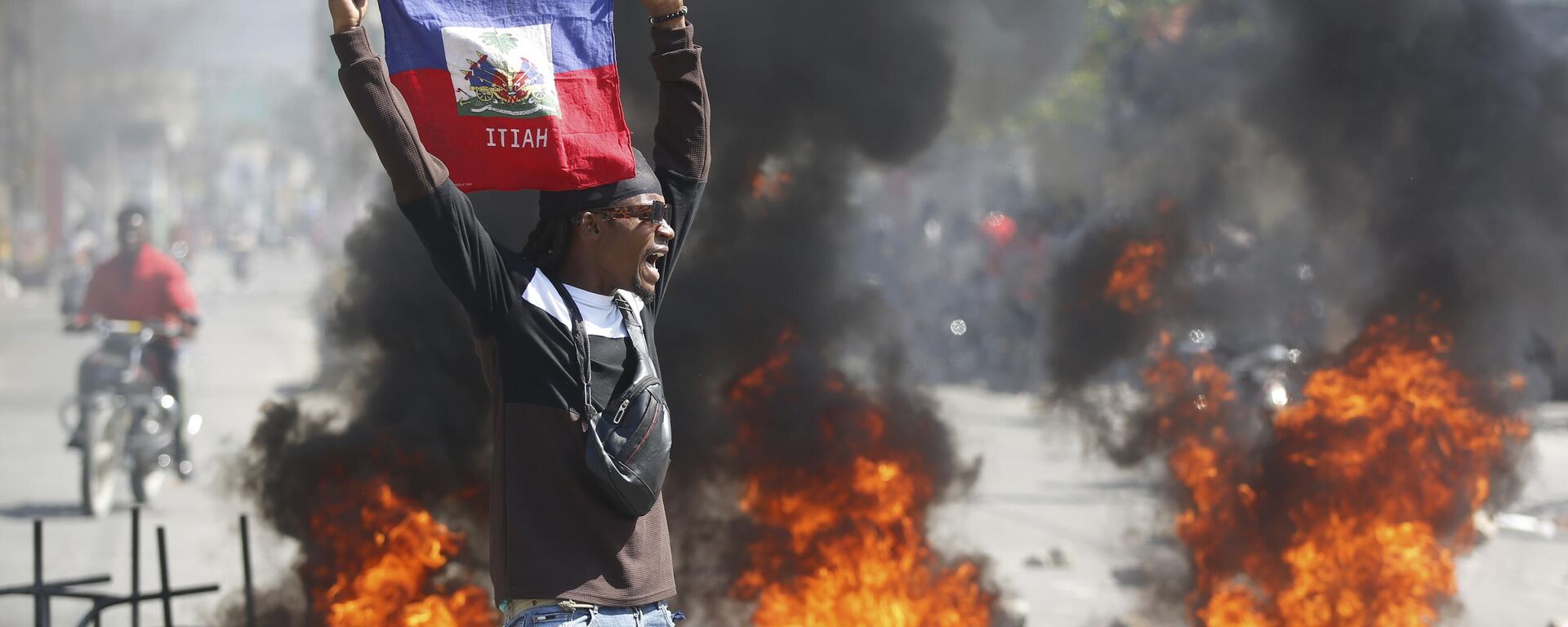 A demonstrator holds up a Haitian flag during protests demanding the resignation of Prime Minister Ariel Henry in Port-au-Prince, Haiti, Friday, March 1, 2024.  - Sputnik Africa, 1920, 13.03.2024