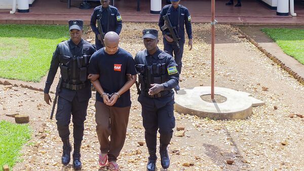 Denis Kazungu, front center, is escorted by police in Kicukiro Primary Court in Kigali, Rwanda, Thursday, Sept.21, 2023. A suspected serial killer in Rwanda on Thursday pleaded guilty at a court on Thursday, saying he killed 14 people. - Sputnik Africa