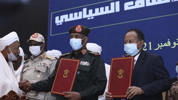 In this photo provided by the Sudan Transitional Sovereign Council, Sudan's top general Abdel Fattah Al-Burhan, center, and then Prime Minister Abdalla Hamdok hold documents attended by Gen. Mohammed Hamdan Dagalo, second left, during a ceremony to reinstate Hamdok, who was deposed in a coup, in Khartoum, Sudan, Nov. 21, 2021. A year after a military takeover upended Sudan’s transition to democracy on Oct. 25, 2021, growing divisions between the two powerful branches of the armed forces are further endangering Sudan’s future. - Sputnik Africa