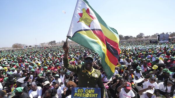 A supporter of Zimbabwean President Emmerson Mnangagwa holds the Zimbabwean flag at a campaign rally in Harare, Wednesday, Aug. 9, 2023.  - Sputnik Africa
