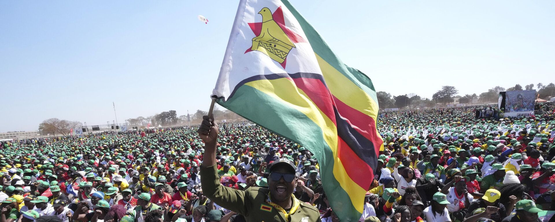 A supporter of Zimbabwean President Emmerson Mnangagwa holds the Zimbabwean flag at a campaign rally in Harare, Wednesday, Aug. 9, 2023.  - Sputnik Africa, 1920, 11.03.2024