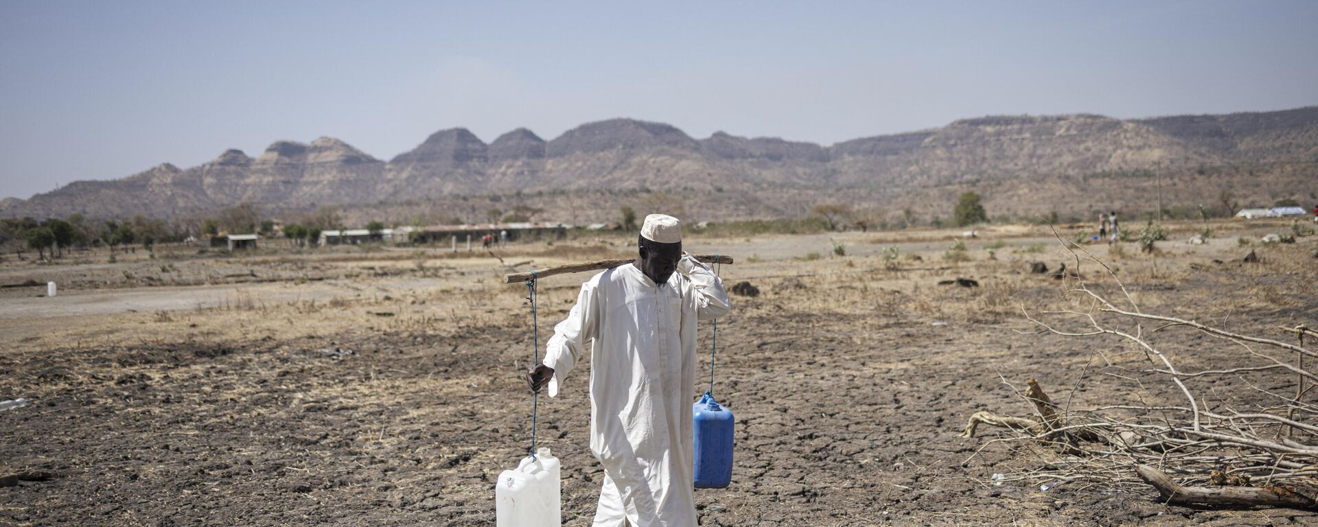 A Sudanese refugee walks back from collecting water in the newly established Awulala refugee camp, near Maganan, 80 km from the Sudanese border in Ethiopia's Amhara region, on February 28, 2024. - Sputnik Africa, 1920, 16.03.2024