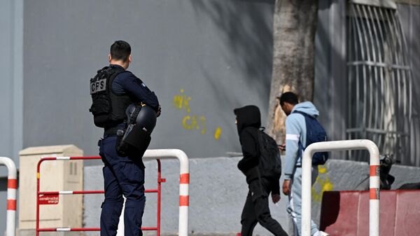 A police officer watches inhabitants ahead of French President Emmanuel Macron's visit focusing on security and the fight against drug trafficking, in La Castellane district of Marseille, southern France, on March 19, 2024.  - Sputnik Africa