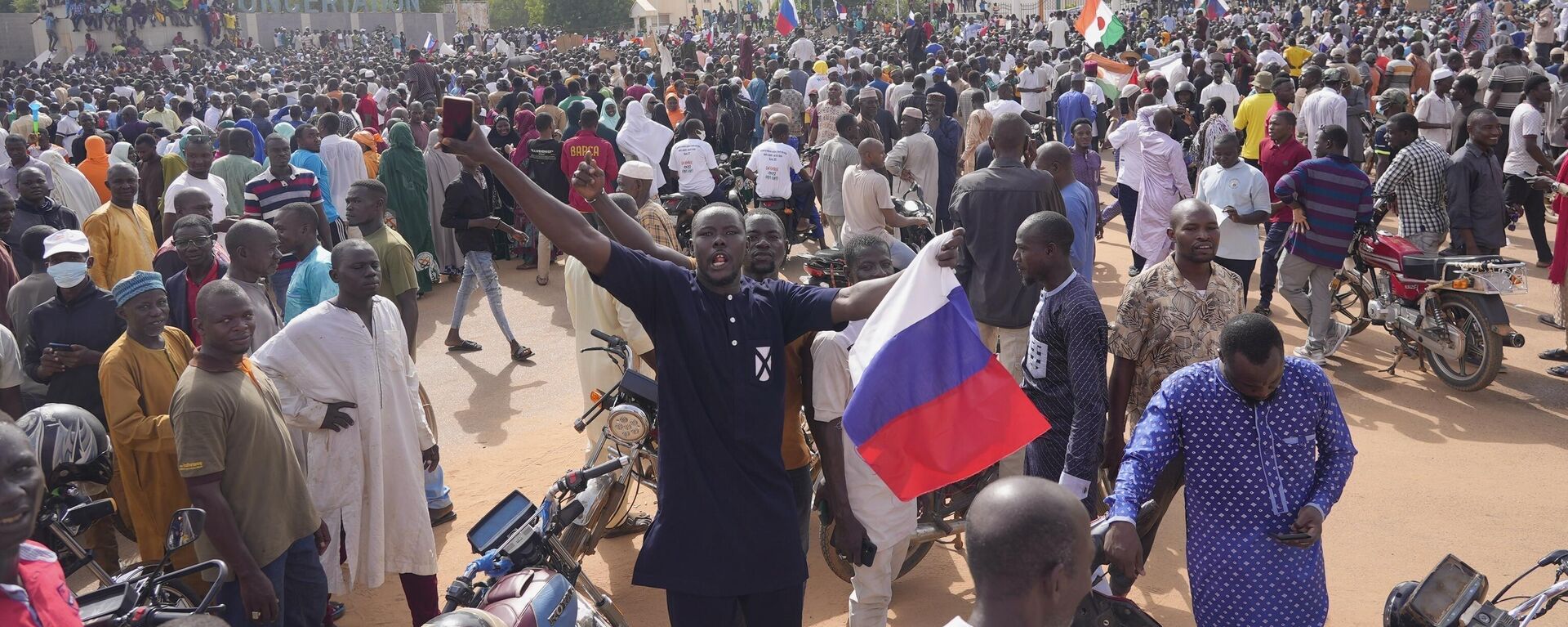 Nigeriens, some holding Russian flags, participate in a march called by supporters of coup leader Gen. Abdourahmane Tchiani in Niamey, Niger, on July 30, 2023.  - Sputnik Africa, 1920, 23.04.2024