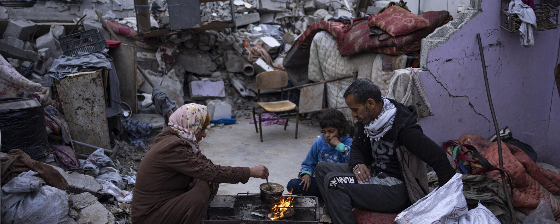Members of the Al-Rabaya family break their fast during the Muslim holy month of Ramadan outside their destroyed home by the Israeli airstrikes in Rafah, Gaza Strip, Monday, March 18, 2024. - Sputnik Africa, 1920, 17.05.2024