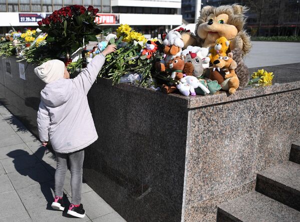A girl laying flowers to honor the memory of the victims in Simferopol, Crimea, Russia. - Sputnik Africa