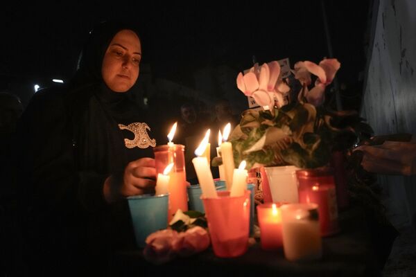 A Lebanese woman lights candles outside the Russian Embassy in Beirut.  - Sputnik Africa