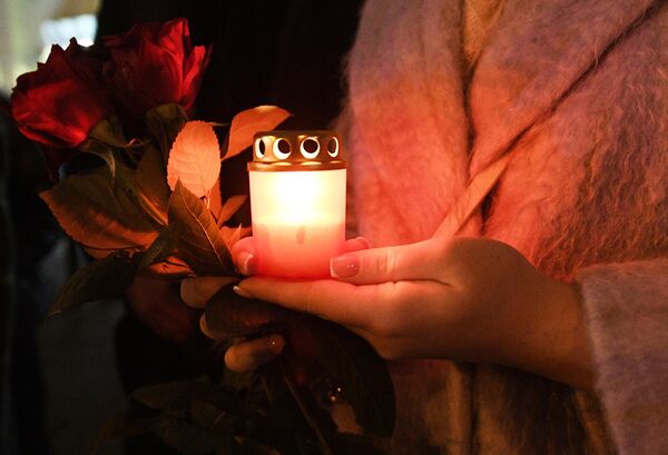 A girl holds a candle near the Russian Embassy in Minsk, Belarus. - Sputnik Africa