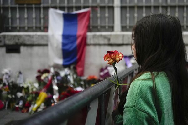 A girl holds a flower outside of the Russian Embassy in Rome.  - Sputnik Africa