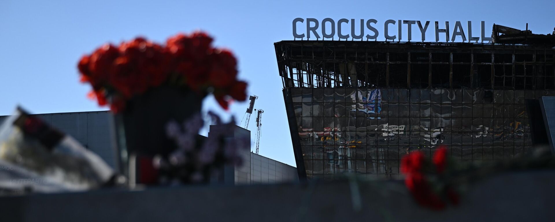 On this Wednesday, March 27, 2024, flowers and toys are placed on the roadside in front of the burnt-out Crocus City Hall following a March 22 terrorist attack on the concert venue in Moscow Region, Russia.  - Sputnik Africa, 1920, 28.03.2024