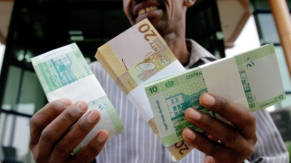 A Sudanese man shows freshly-minted notes of the new Sudanese pound in Khartoum on July 24, 2011 as the country issues new currency following the South's secession from the north. - Sputnik Africa