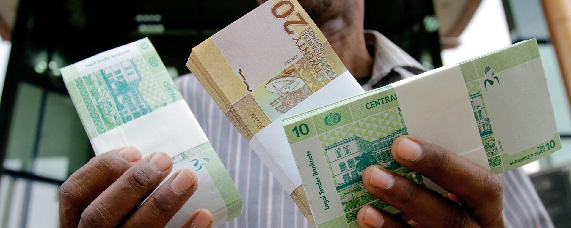 A Sudanese man shows freshly-minted notes of the new Sudanese pound in Khartoum on July 24, 2011 as the country issues new currency following the South's secession from the north. - Sputnik Africa, 1920, 23.04.2024