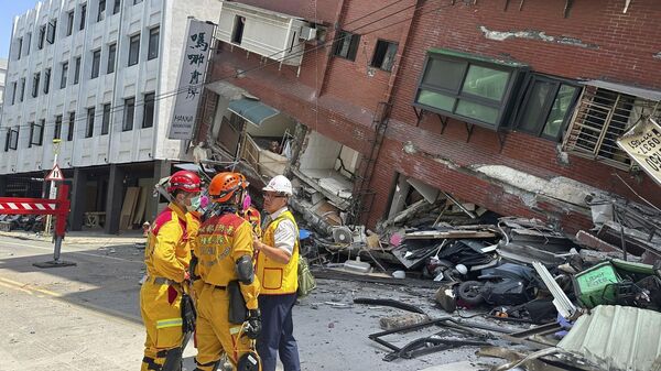 Members of a search and rescue team prepare outside a leaning building in the aftermath of an earthquake in Hualien, eastern Taiwan. - Sputnik Africa