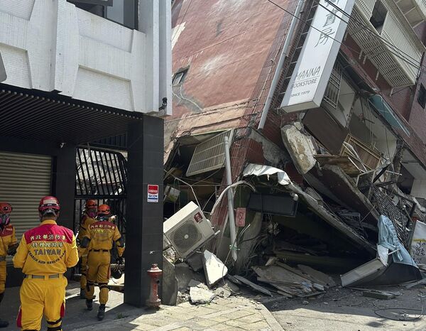 In this photo released by the National Fire Agency, members of a search and rescue team prepare outside a leaning building in the aftermath of an earthquake in Hualien, eastern Taiwan. - Sputnik Africa