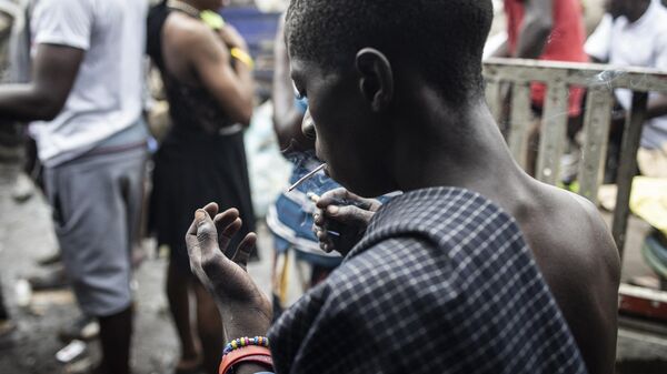 A young man stares at his hand as he smokes Kush inside a drug den at the Kington landfill site in Freetown on June 21, 2023.  - Sputnik Africa