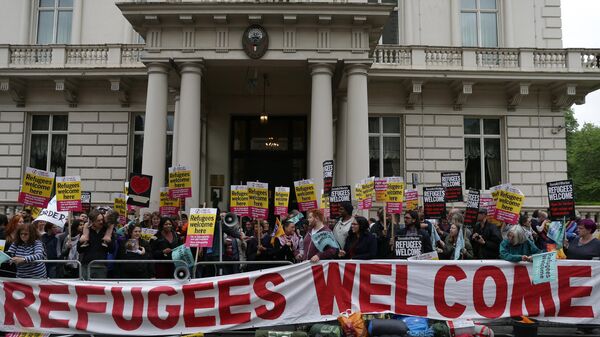 Pro-refugee protesters hold placards as they gather to protest outside the French Embassy in central London on June 18, 2016 after most of an aid convoy vehicles organized by campaign groups were turned back at the French frontier in the port of Dover.  - Sputnik Africa
