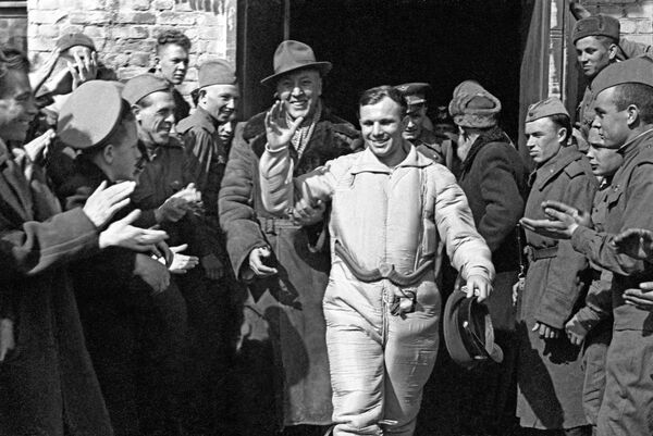 The world&#x27;s first cosmonaut Yuri Gagarin after the landing of the Vostok-1 spacecraft lander. Gagarin is surrounded by a search team led by the commander of the missile division, Major A.Gassiev, and local residents. - Sputnik Africa