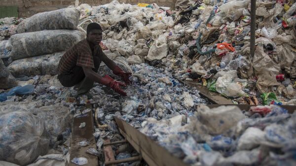 A worker sorts plastic for recycling into blocks which can be used in road construction at the Nelplast Ghana Ltd factory in Ashaiman, suburban Accra on April 6, 2018. - Sputnik Africa