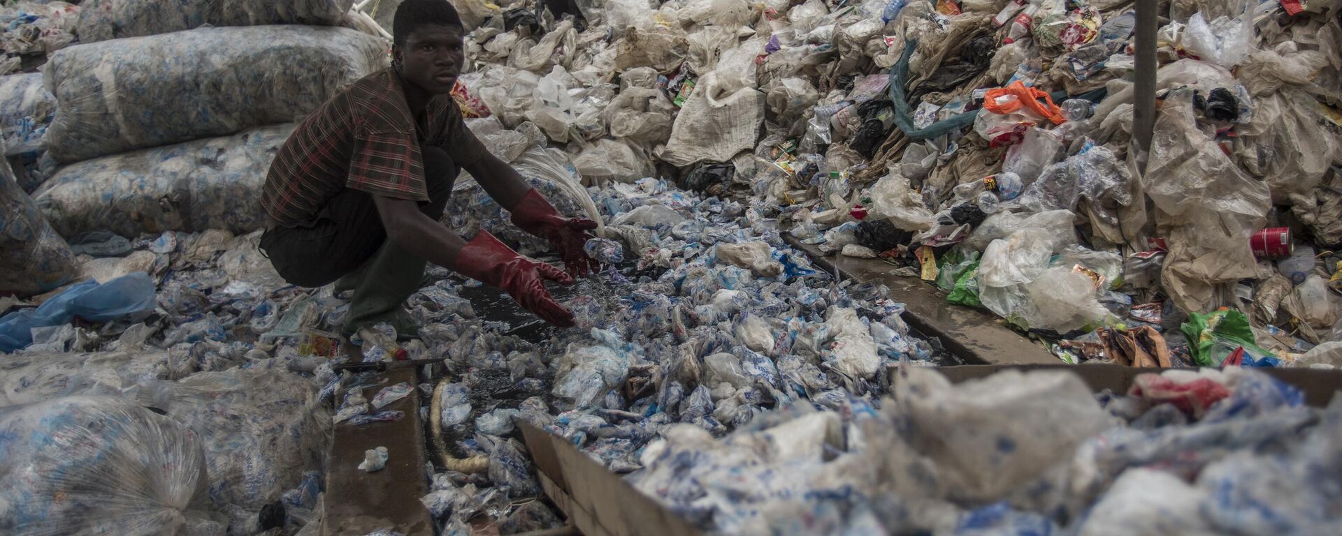 A worker sorts plastic for recycling into blocks which can be used in road construction at the Nelplast Ghana Ltd factory in Ashaiman, suburban Accra on April 6, 2018. - Sputnik Africa, 1920, 08.04.2024