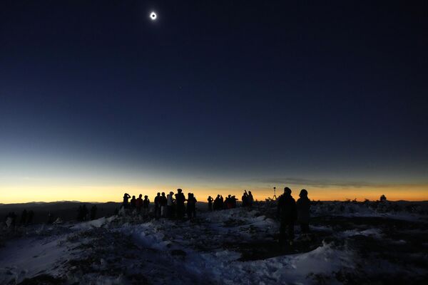 Skiers and hikers take in the view from the Appalachian Trail at the summit of Saddleback Mountain during the total solar eclipse. - Sputnik Africa