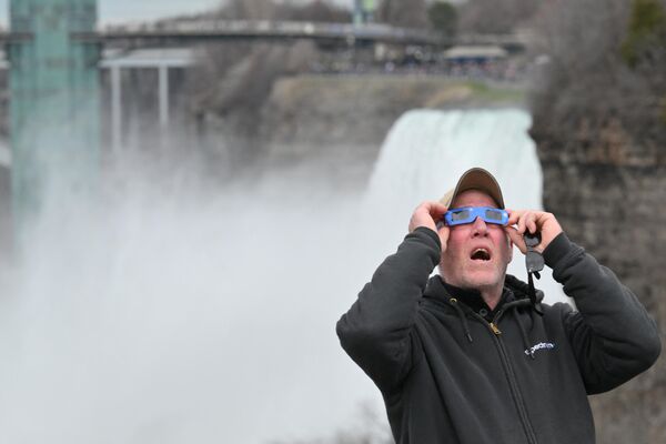 A man views the total solar eclipse at Niagara Falls State Park in Niagara Falls, New York. - Sputnik Africa