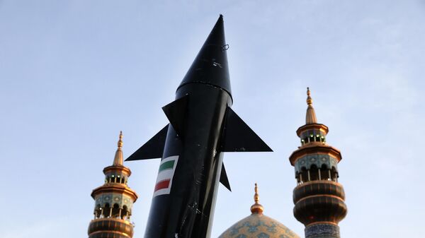 A model of a missile is carried by Iranian demonstrators as minarets and dome of a mosque is seen at background during an anti-Israeli gathering at the Felestin (Palestine) Sq. in Tehran, Iran, Monday, April 15, 2024. - Sputnik Africa