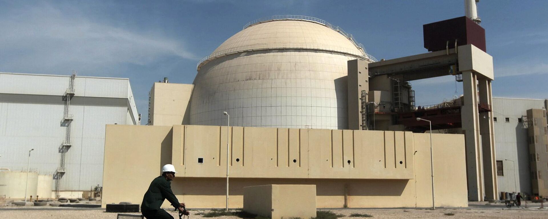 A worker rides a bicycle in front of the reactor building of the Bushehr nuclear power plant, just outside the southern city of Bushehr, Iran, Oct. 26, 2010. - Sputnik Africa, 1920, 16.04.2024