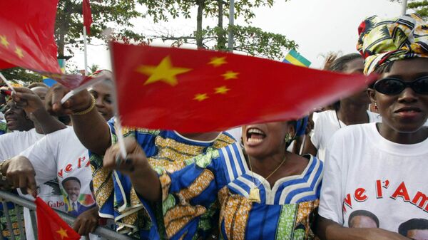 Members of Gabon's Democratic party sing and wave Chinese flags at Chinese president, Hu Jintao's arrival at Leon Mba airport in Libreville, 01 February 2004. - Sputnik Africa
