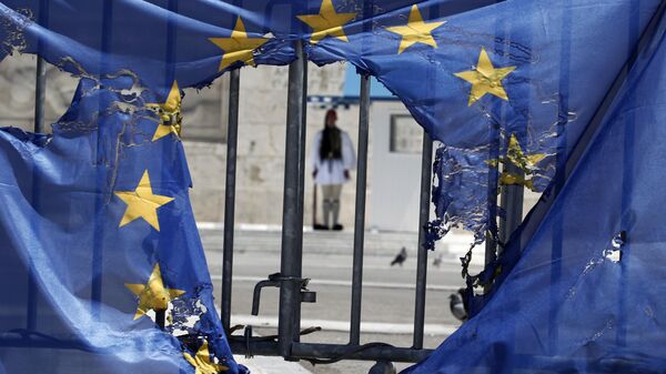 A Greek presidential guard stands framed bythe remains of a European Union flag half-burnt by protesters in Athens, on Wednesday, May 1, 2013 - Sputnik Africa