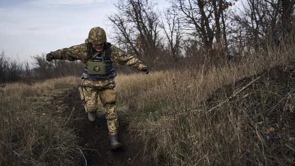 A Ukrainian soldier runs for cover during fights with Russian forces near Maryinka, Ukraine, Friday, Dec. 23, 2022. - Sputnik Africa