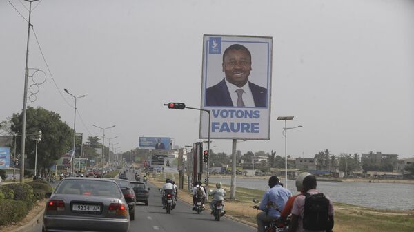 Cars drive past election posters of Togo's Incumbent President Faure Gnassingbe, Presidential Candidate of Union for the Republic, on the street in Lome, Togo Friday, Feb. 21, 2020. - Sputnik Africa