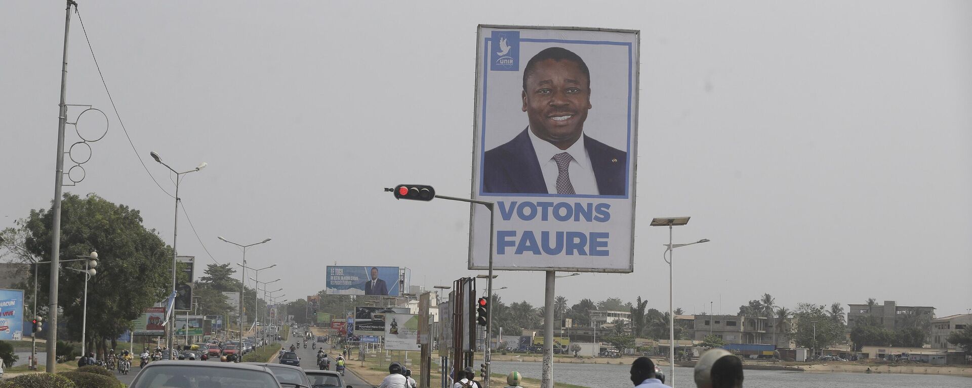 Cars drive past election posters of Togo's Incumbent President Faure Gnassingbe, Presidential Candidate of Union for the Republic, on the street in Lome, Togo Friday, Feb. 21, 2020. - Sputnik Africa, 1920, 28.04.2024