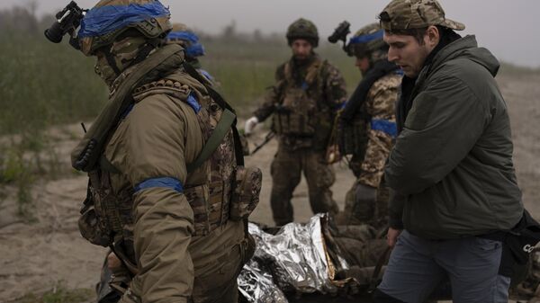 Украинские военные переносят раненого сослуживца - Sputnik Africa