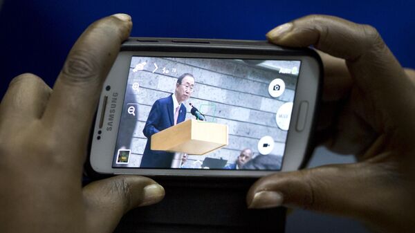 A delegate takes photographs on her smartphone as UN Secretary-General Ban Ki-moon speaks at a meeting of the Africa Sustainable Transport Forum, at the United Nations Office in Nairobi, Kenya, Thursday, Oct. 30, 2014.  - Sputnik Africa