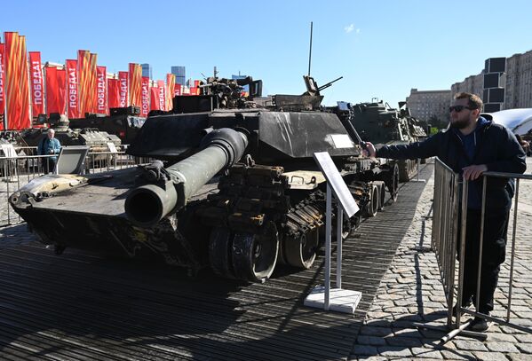 A visitor takes a picture of a trophy Abrams tank captured by Russian servicemen during a special military operation. - Sputnik Africa