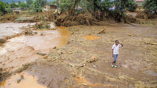A child walks through an area after a river broke through a blocked tunnel causing floodwaters in the Mai Mahiu area of Nakuru County, Kenya, Monday, April 29, 2024. - Sputnik Africa