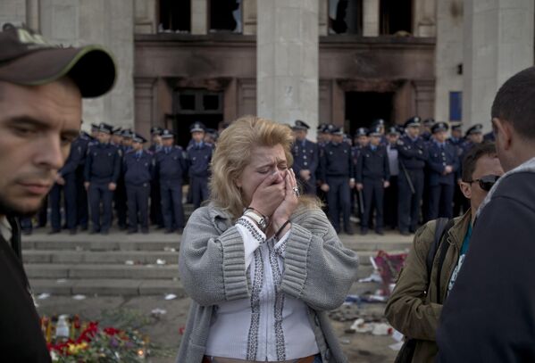 A woman cries back dropped by police troops guarding the burnt trade union building in Odessa, Ukraine, Saturday, May 3, 2014. - Sputnik Africa