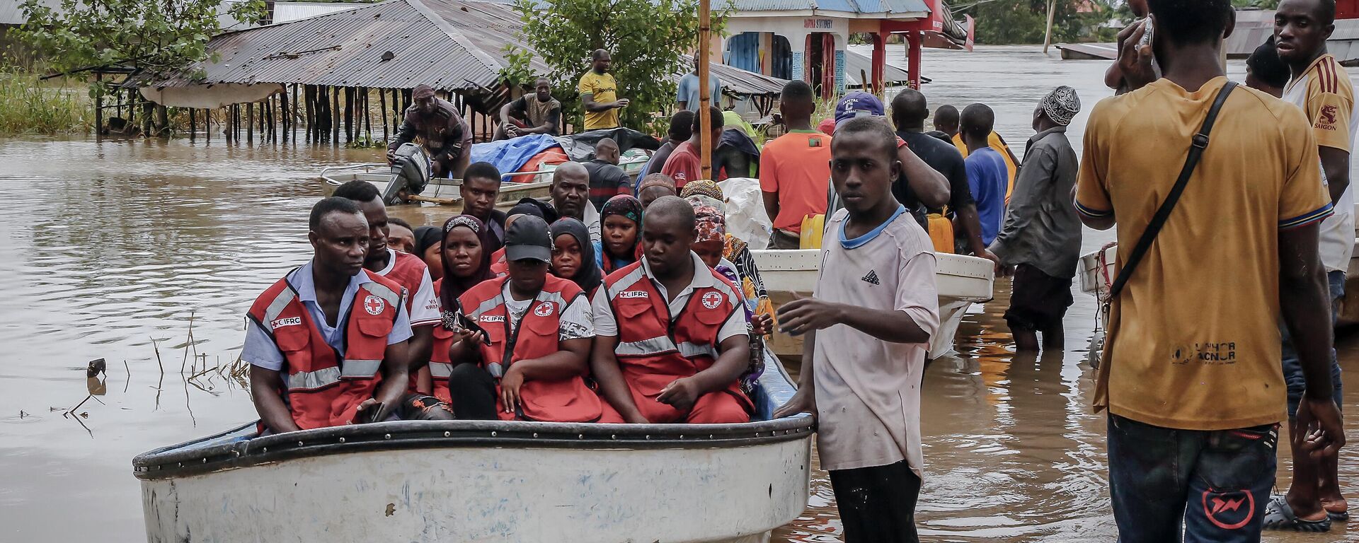 Members of the International Federation of Red Cross and Red Crescent Societies (IFRC) gather on a boat as residents are rescued in an area heavily affected by floods following torrential rains in the Rufiji District village of Mohoro, on April 17, 2024.  - Sputnik Africa, 1920, 05.05.2024