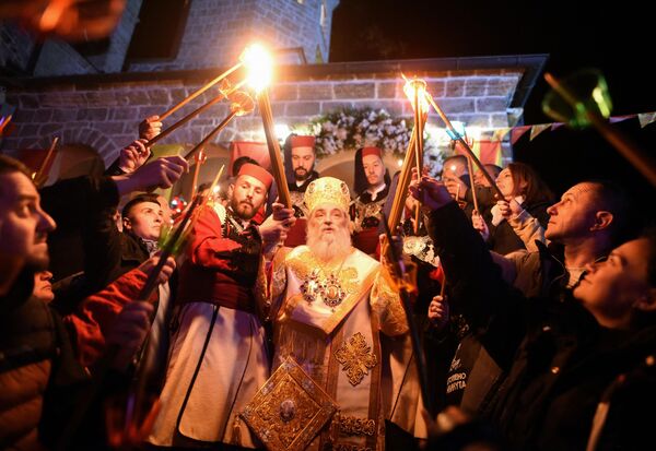 Macedonian Orthodox Christians light candles from the holy fire that arrived from Jerusalem during an Easter service at the Saint Jovan Bigorski monastery in Mavrovo, some 115km west of the capital Skopje, early on May 5, 2024. The Macedonian Orthodox Church celebrated Easter according to the Julian calendar. - Sputnik Africa