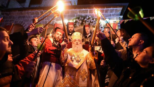 Macedonian Orthodox Christians light candles from the holy fire that arrived from Jerusalem during an Easter service at the Saint Jovan Bigorski monastery in Mavrovo, some 115km west from the capital Skopje, early on May 5, 2024. - Sputnik Africa