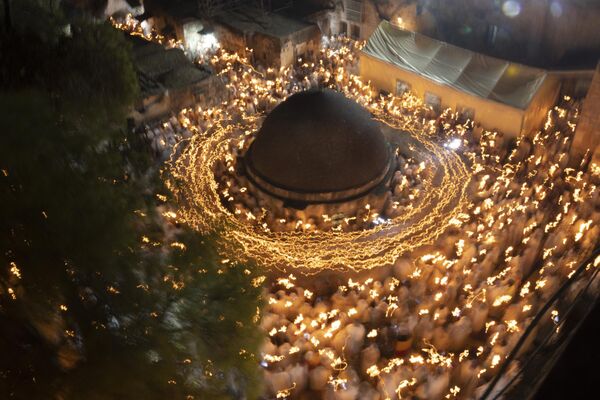 Ethiopian Orthodox Christian pilgrims hold candles during a ceremony of the &quot;Holy Fire&quot; at the Deir Al-Sultan Monastery on the roof of the Holy Sepulchre Church in Jerusalem&#x27;s Old City on May 4 2024, on the eve of Orthodox Easter.  - Sputnik Africa