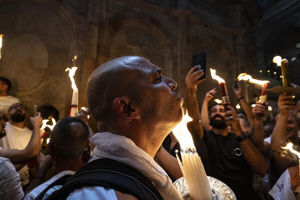 Orthodox Christians gather with lit candles during the Holy Fire ceremony at the Holy Sepulchre church in Jerusalem&#x27;s Old City on May 4, 2024, on the eve of Easter Sunday.  - Sputnik Africa