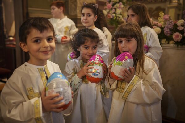 Children of the Armenian community hold chocolate eggs that they received at the end of an Orthodox Easter religious service at the Armenian cathedral in Bucharest, Romania, on Saturday, May 4, 2024.  - Sputnik Africa