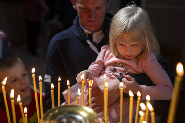 Believers light candles after a cake and Easter egg blessing ceremony at the Orthodox Church of the Holy Spirit in Vilnius, Lithuania, on Saturday, May 4, 2024. - Sputnik Africa