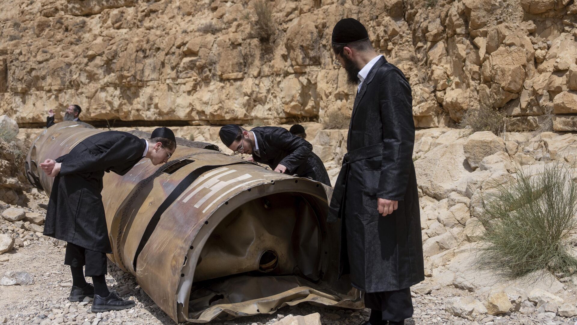 Ultra-Orthodox Jews observe the part of the intercepted ballistic missile that fell in the desert near the city of Arad, Israel, Sunday, April 28, 2024. - Sputnik Africa, 1920, 05.05.2024