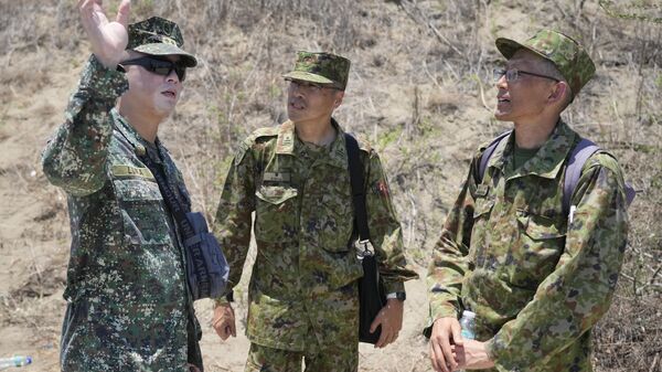 Members from Japan's Self-Defense Forces, right, talk with Philippine counterparts as they observe a joint military exercise on Wednesday, May 8, 2024, in Laoag, Ilocos Norte, northern Philippines - Sputnik Africa