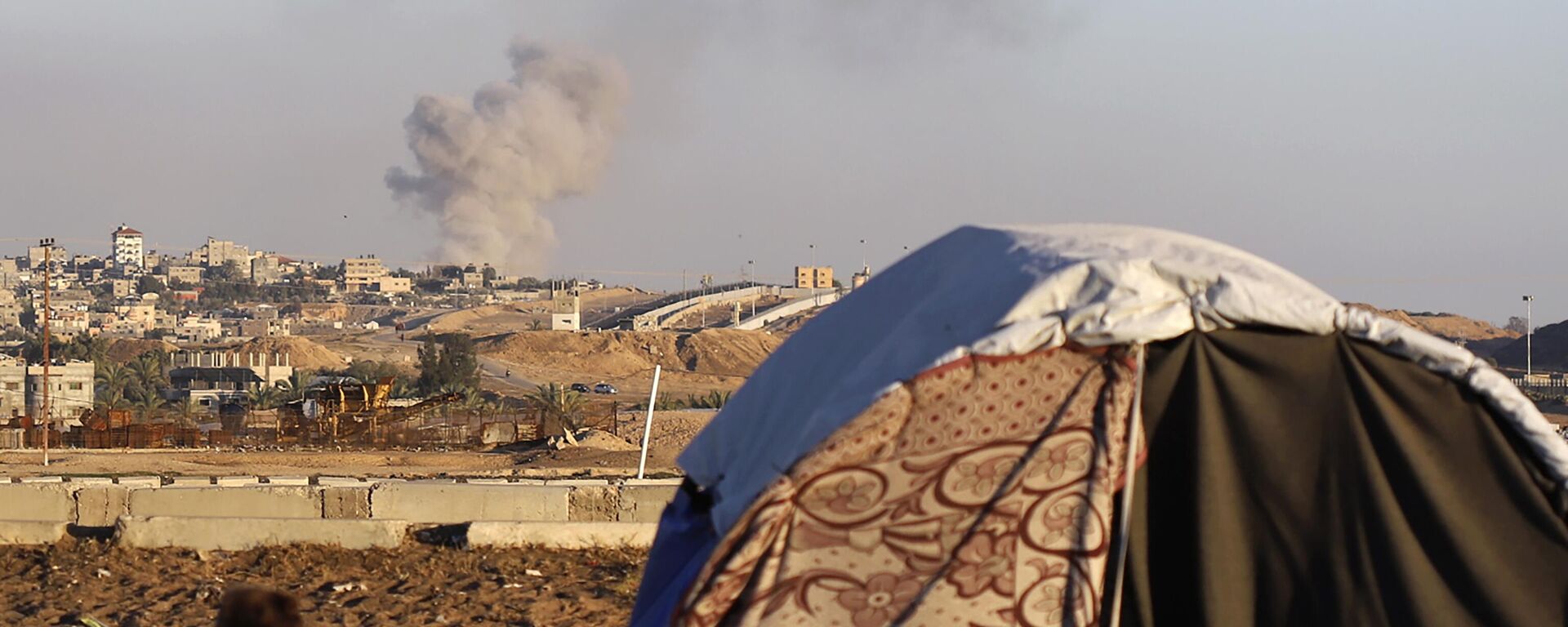 Smoke rises following an Israeli airstrike on buildings near the separating wall between Egypt and Rafah, southern Gaza Strip, Tuesday, May 7, 2024.  - Sputnik Africa, 1920, 25.06.2024