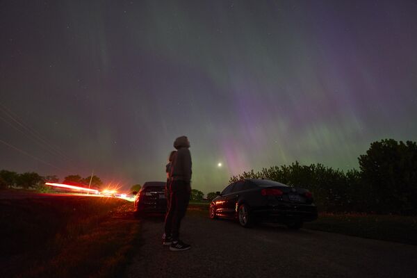 People stop along a country road near London, Ontario in Canada to watch the Northern lights or aurora borealis. - Sputnik Africa